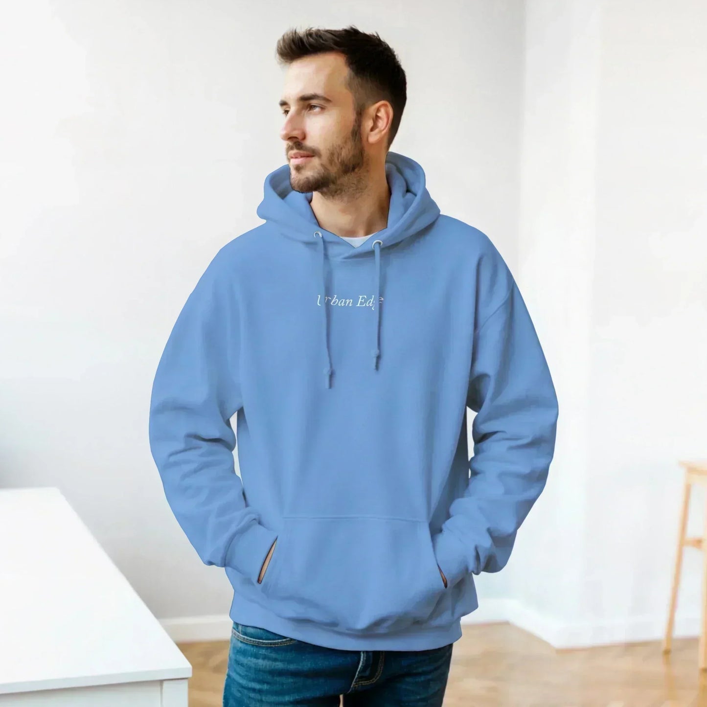 Man wearing classic unisex pullover hoodie in light blue with front pouch pocket and adjustable drawstring hood indoors