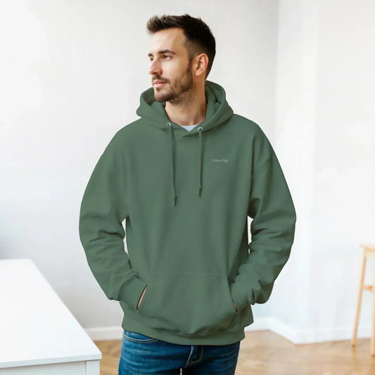Man wearing green Gildan® 18500 classic unisex pullover hoodie with front pouch pocket and drawstring hood indoors